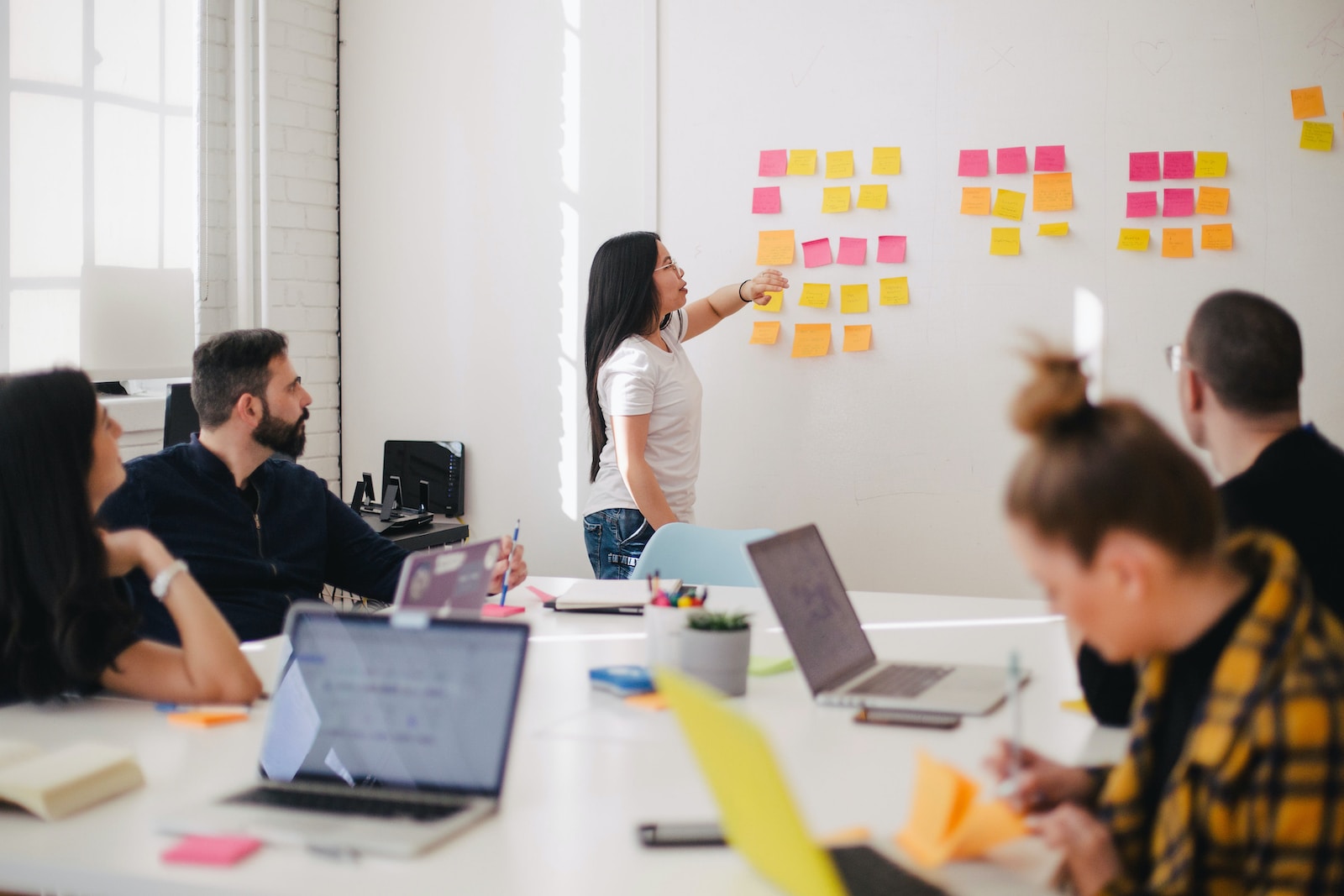 Digital marketing skills. woman placing sticky notes on wall